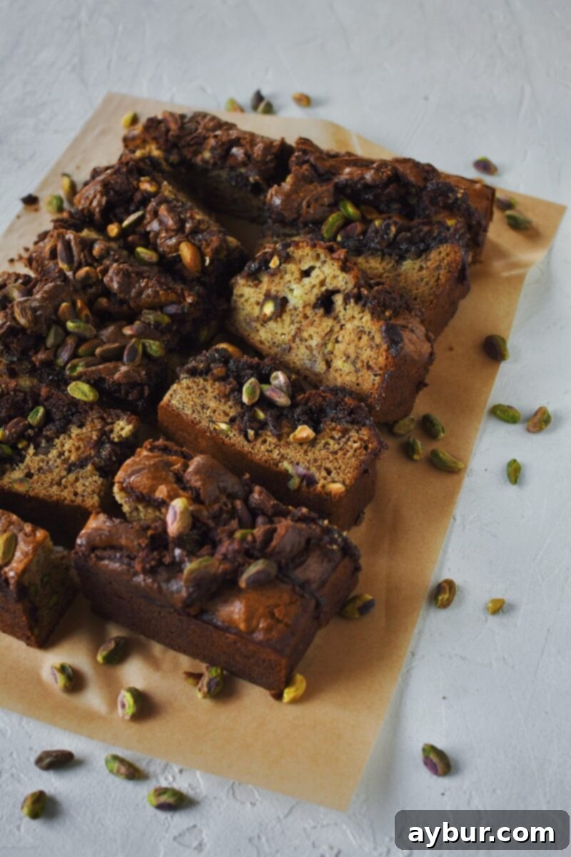 Pistachio Banana Bread all sliced with pistachios spread around it.