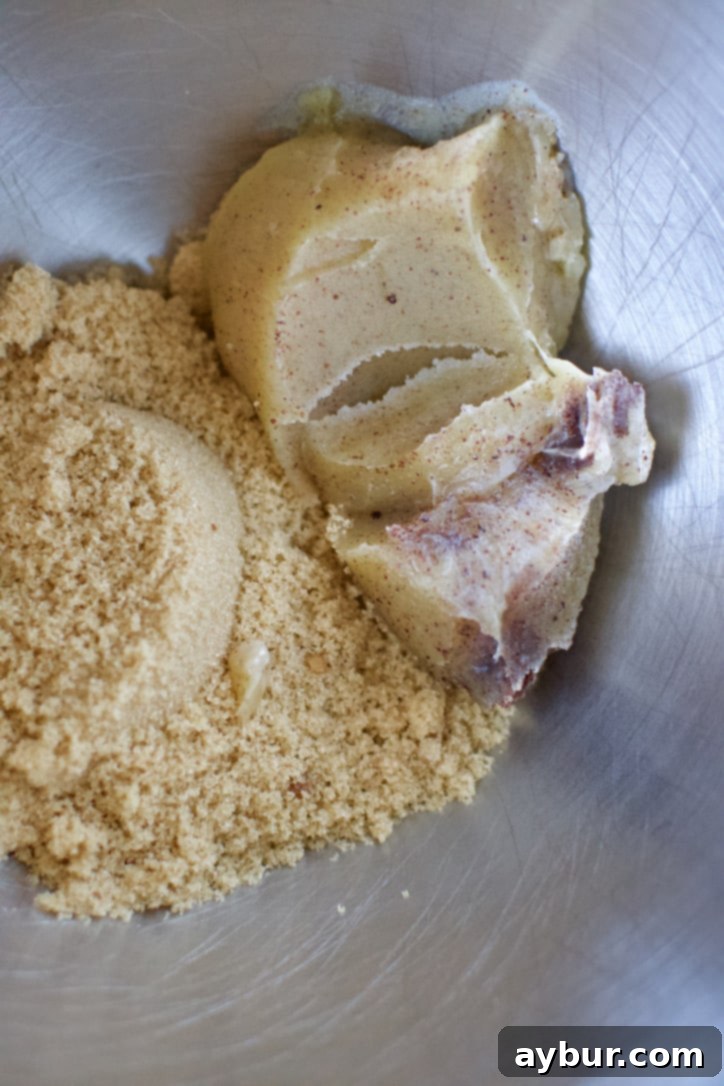 Cooled browned butter in the bowl of a stand mixer with the sugar ready to be creamed together.
