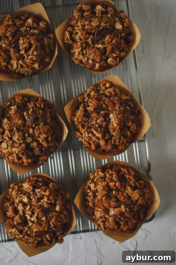 A selection of freshly baked Pumpkin Banana Muffins with pecan topping on a cooling rack.