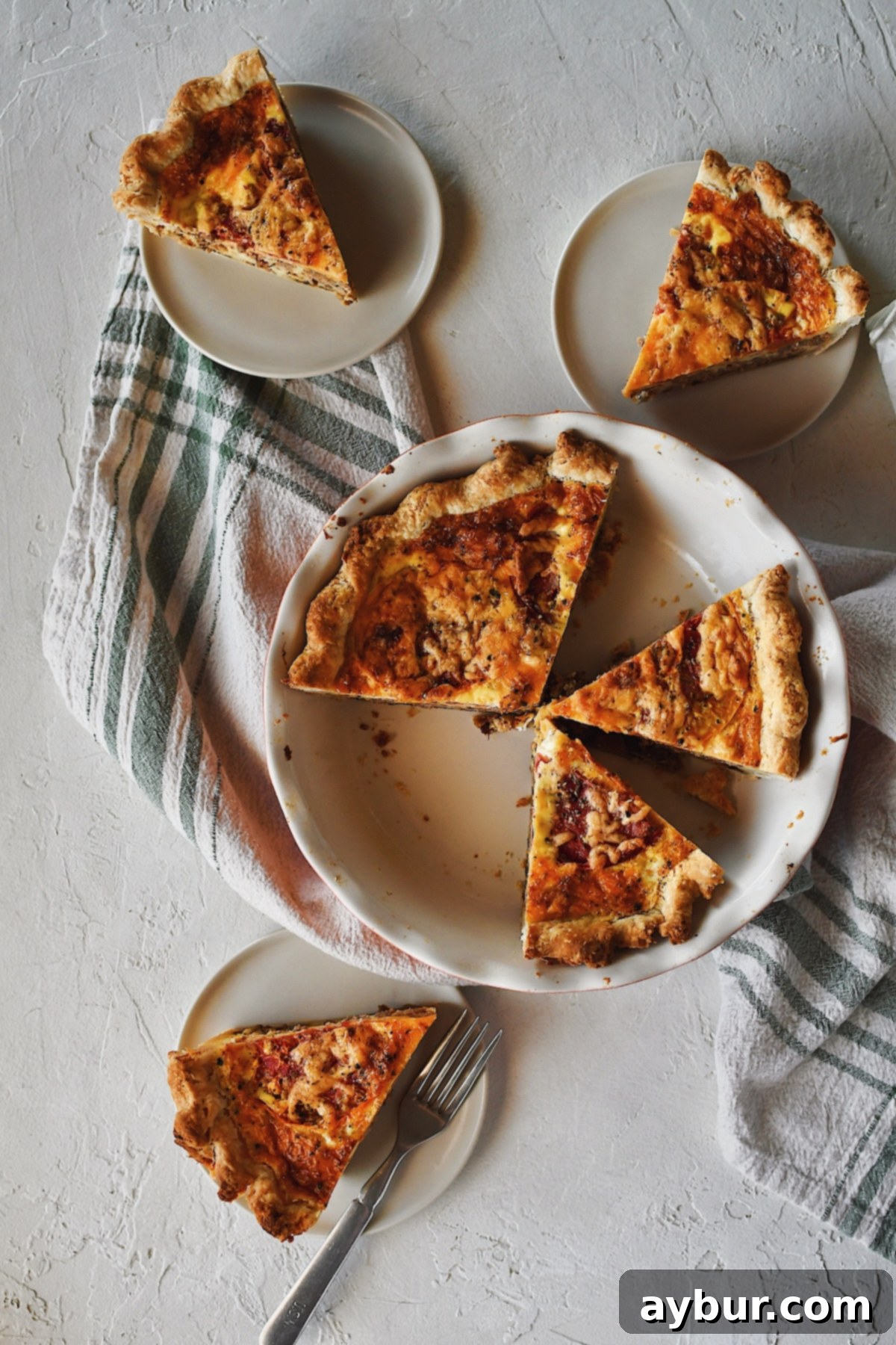 Loaded Cheeseburger Pie 3 Looking down at a sliced Cheeseburger Pie, with a few sliced removed and on plates around it.