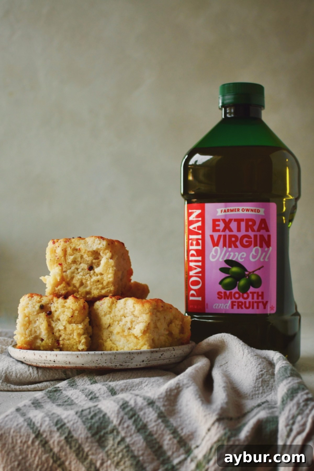 Mediterranean Olive Oil Bites 2 Cooked Olive Oil Swim Biscuits on a plate next to a bottle of olive oil.