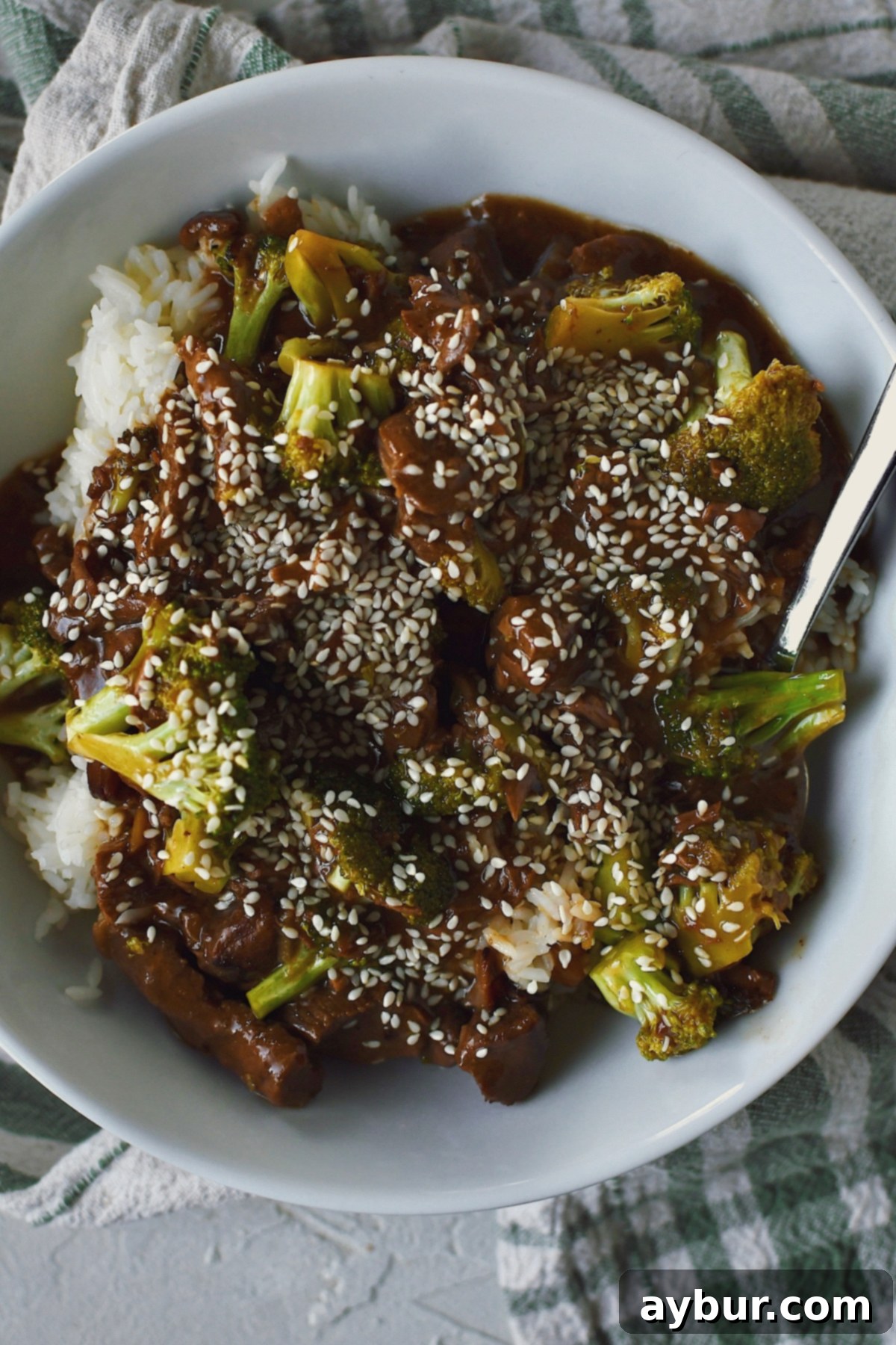 Looking down into a bowl of Slow Cooker Beef and Broccoli served over rice.