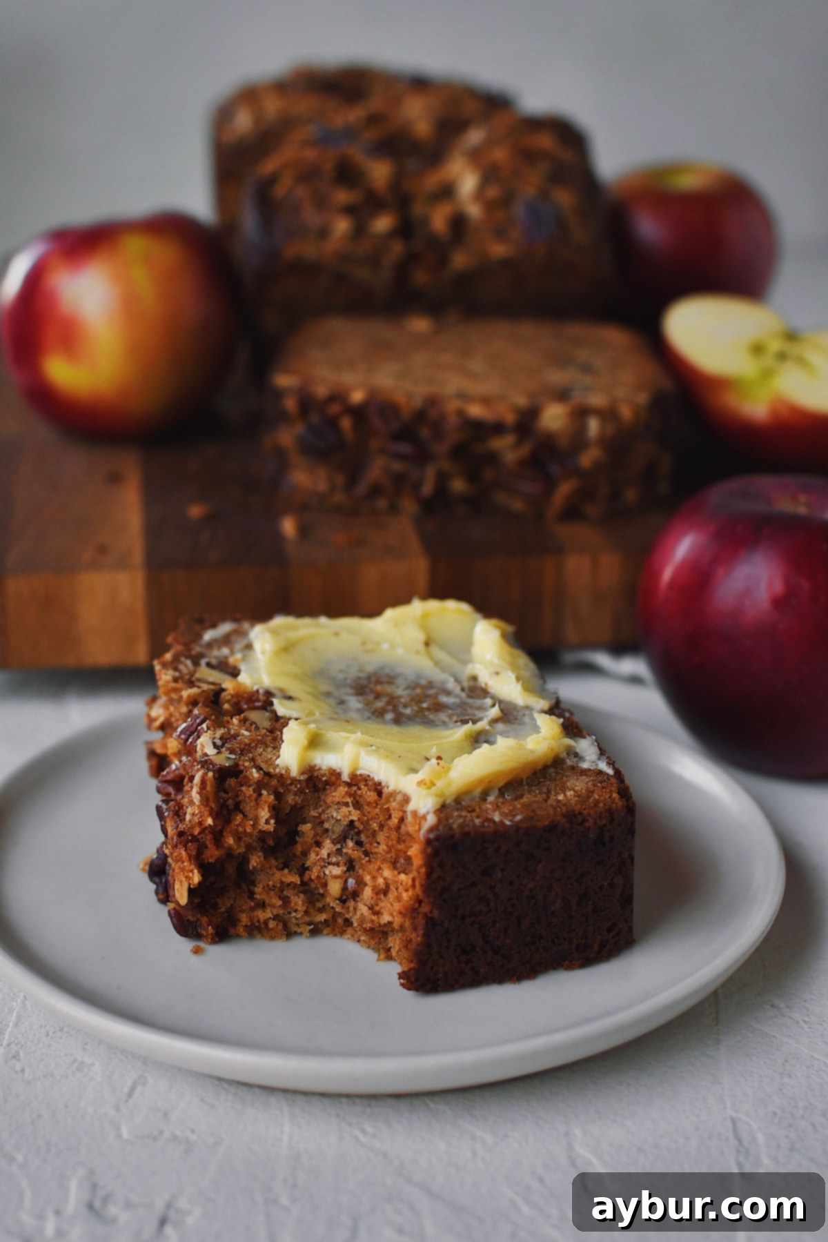 Looking into a slice of Apple Bread that has a bite taken out of it and butter spread on top.