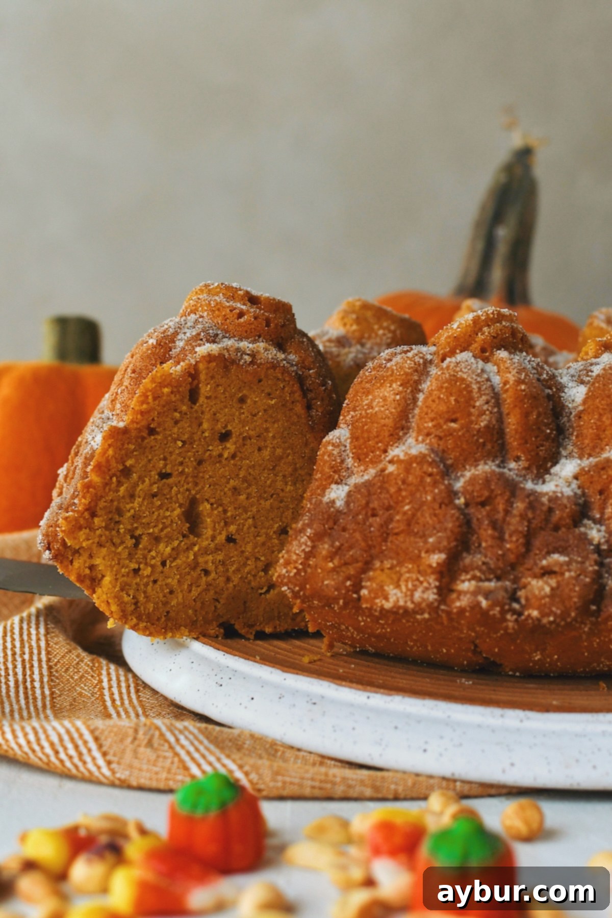 Pumpkin Spice Donut Bundt Cake 4 Cutting out a slice of Pumpkin Donut Bundt Cake, revealing its moist, tender crumb.