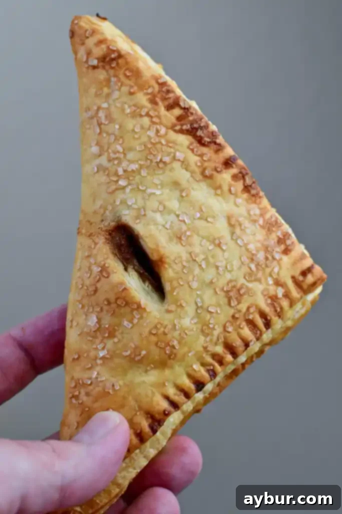 Close-up of baked apple turnover showing the distinct flaky layers of puff pastry