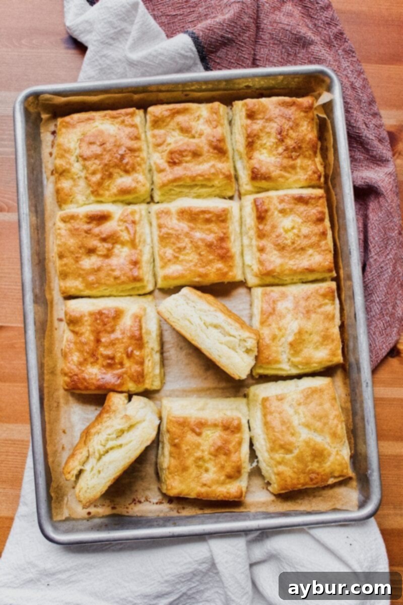 A glorious stack of perfectly golden and fluffy Jojo's Biscuits, fresh from the oven, embodying the ideal rise and texture achieved with Joanna Gaines' recipe from the Magnolia Table Cookbook.