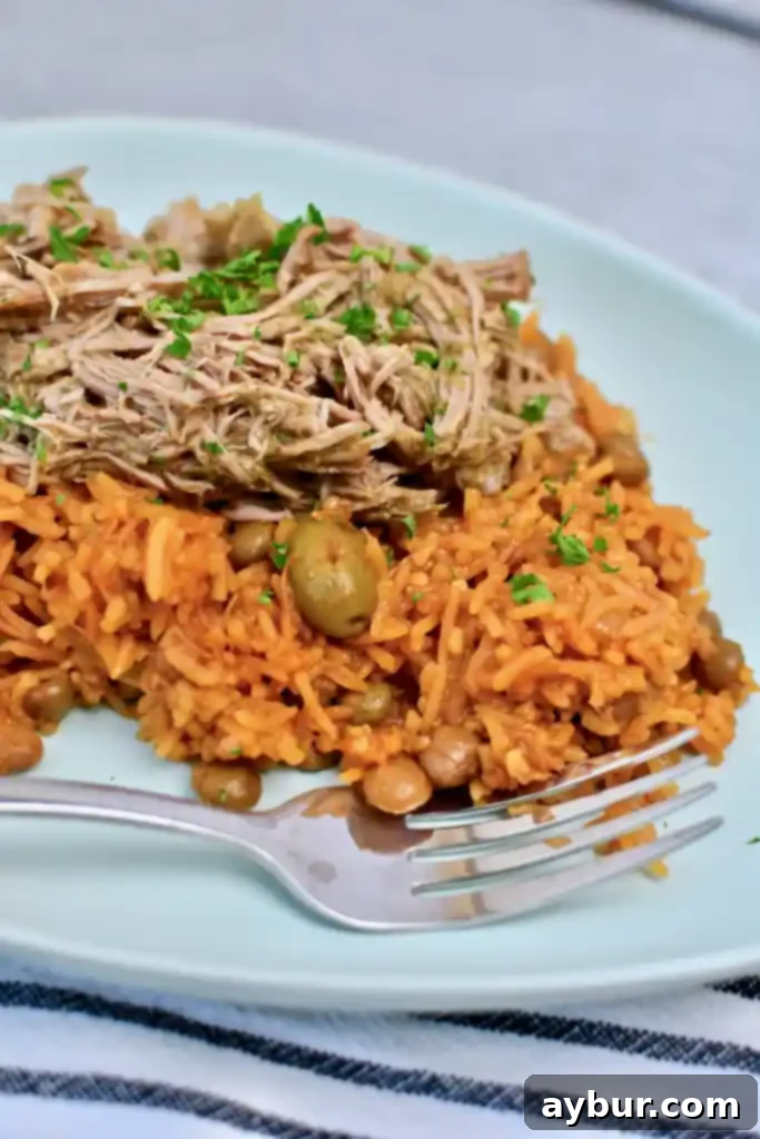 A generous serving of Arroz con Gandules beautifully presented with roasted pork on top