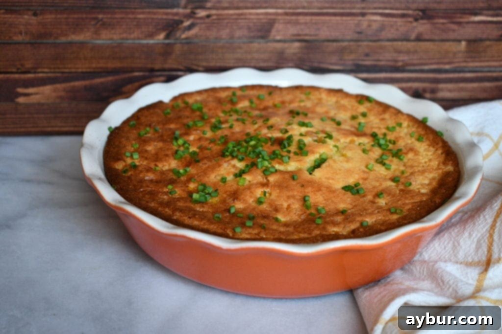 A close-up of the spoonbread's creamy, corn-flecked interior, showing its soft texture.