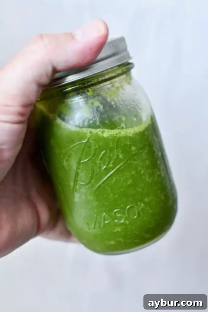 Puerto Rican Sofrito 2 Freshly blended Puerto Rican Sofrito in a glass jar, vibrant green and ready to use in a kitchen setting.