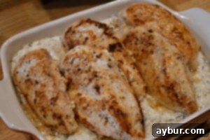 Seared chicken breasts placed on top of the rice and bacon layers for the Magnolia Table recipe