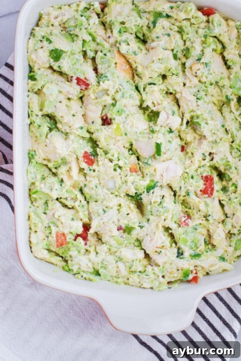 Ingredients for Chicken Enchilada Casserole being mixed in a baking dish