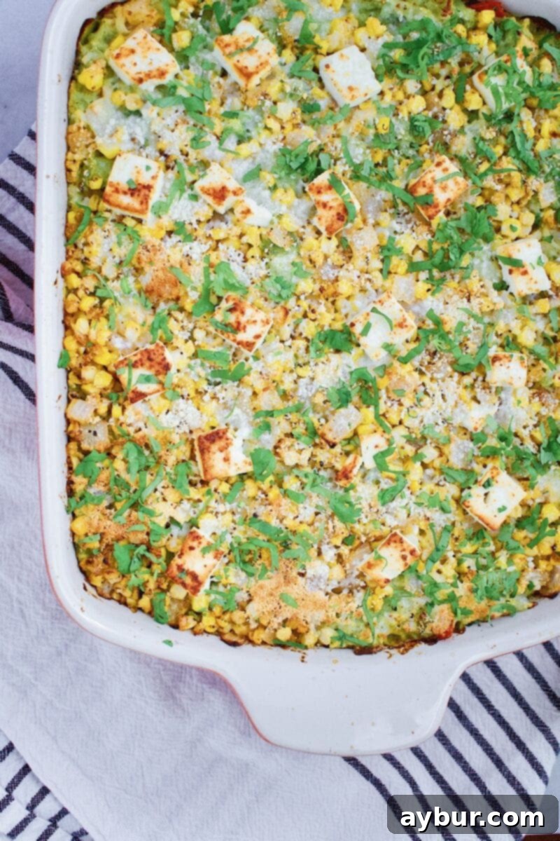 Close-up of a serving of Chicken Enchilada Casserole with street corn topping