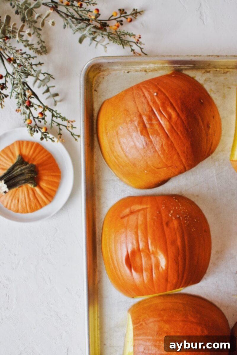 Golden Homemade Pumpkin Puree 7 A freshly roasted pumpkin half, still on the baking sheet, being gently pressed with tongs to check for tenderness, indicating it's perfectly cooked.