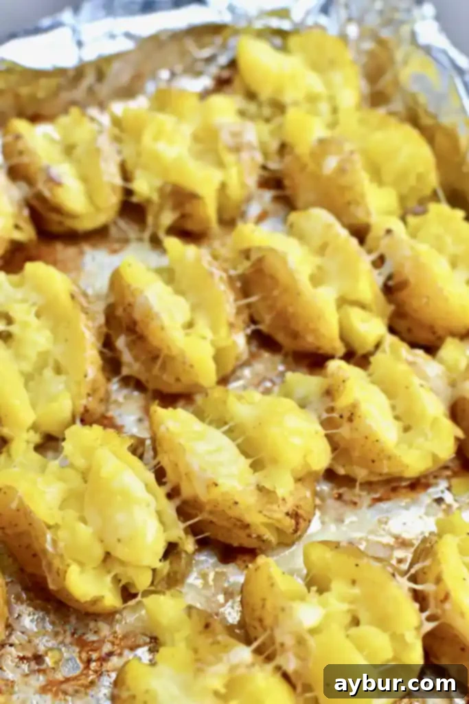 Close-up of a single Loaded Baked Potato Bite, with cheese bubbling under the broiler, ready for toppings.