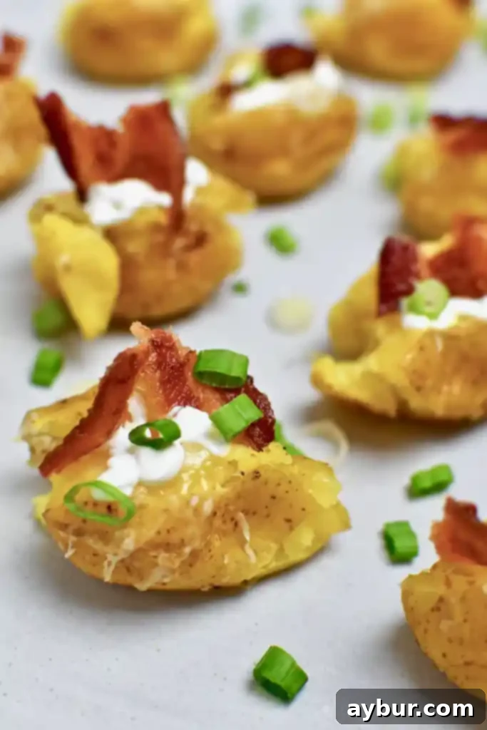 Finished Loaded Baked Potato Bites arranged on a platter, garnished with sour cream, bacon, and chives.