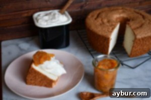 A close-up shot of a slice of Angel Food Cake, highlighting its airy, open crumb and perfectly white interior, suggesting a delicate, melt-in-your-mouth texture.