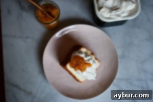 A elegant slice of Angel Food Cake, perfectly plated and garnished with a medley of fresh, vibrant berries and a swirl of light whipped cream, ready to be enjoyed.