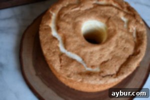 A charming vignette featuring a variety of freshly baked goods, including a focus on Angel Food Cake slices, arranged artfully on a rustic wooden table, evoking a sense of cozy indulgence.