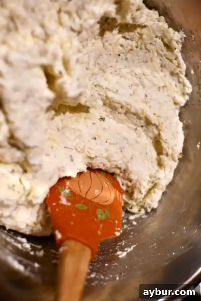 Seasoned ricotta cheese mixture in a bowl, creamy and ready for layering