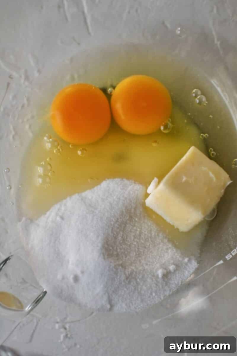 Starting the donut dough by whisking together the butter, sugar, and eggs.