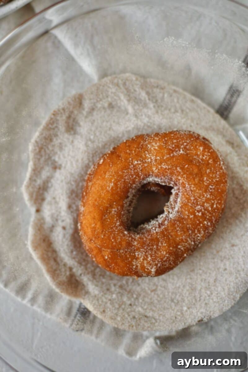 Dusting the donuts with the pumpkin spice sugar.