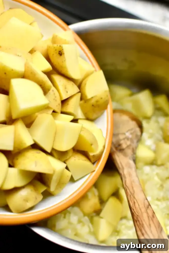 Plant-Based Creamy Potato Soup 6 Adding potatoes to the butter, onions and garlic