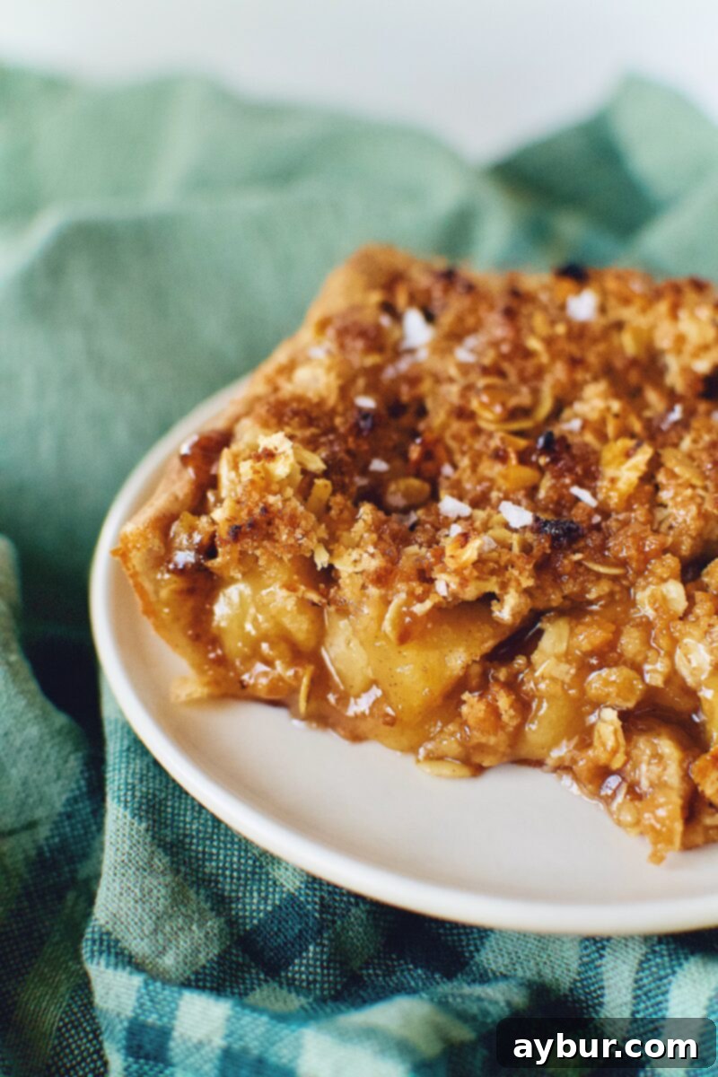 A golden-brown slice of Honeycrisp Apple Slab Pie, ready to be enjoyed, showcasing the crispy crust and crumble topping.