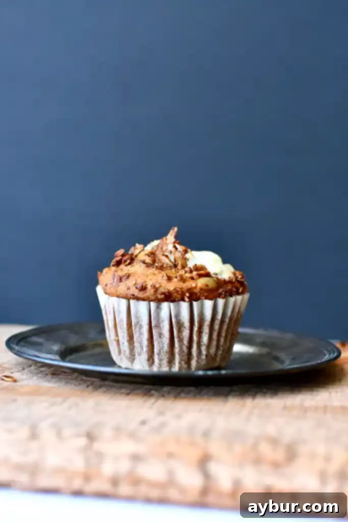 Homemade Starbucks-Inspired Pumpkin Cream Cheese Muffins 2 Close-up of a homemade Starbucks-style pumpkin cream cheese muffin with a creamy swirl and granola topping