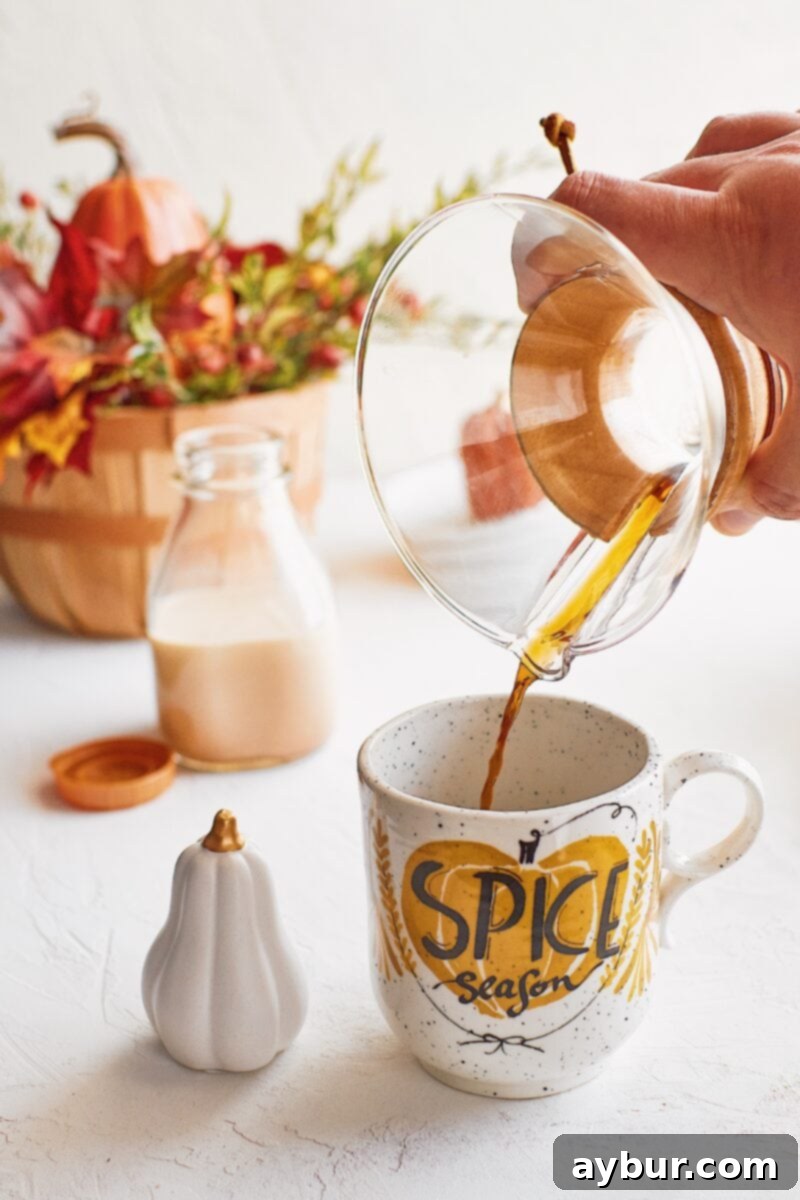 Pumpkin Spice Creamer 3 Coffee being poured into a mug that reads 'Pumpkin Spice Season'