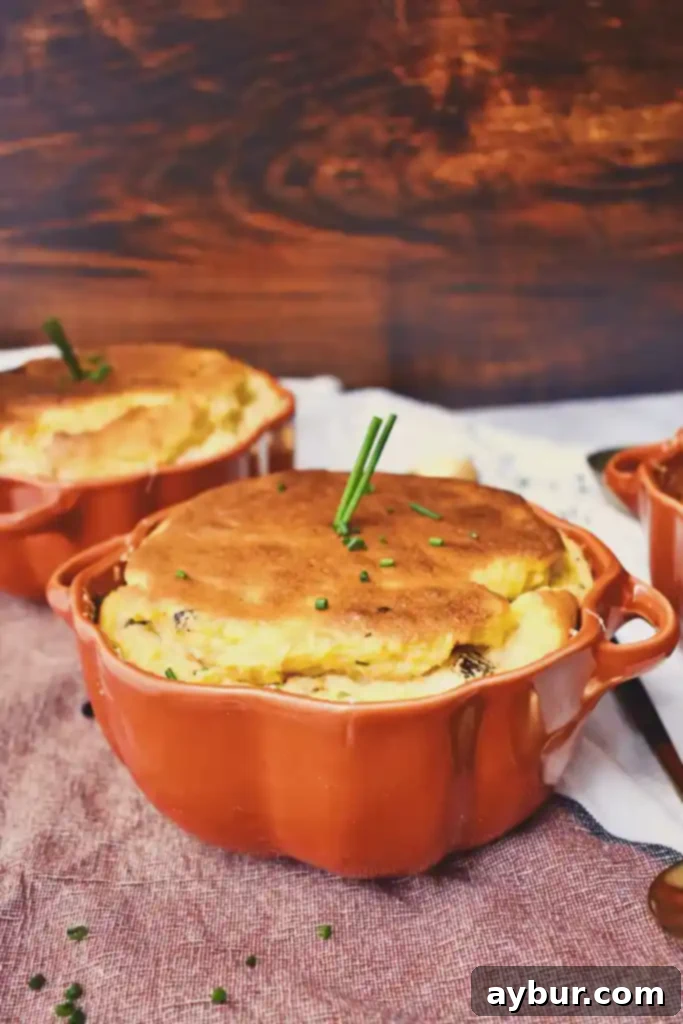 Airy Pumpkin Goat Cheese Soufflé, freshly baked in a white ramekin
