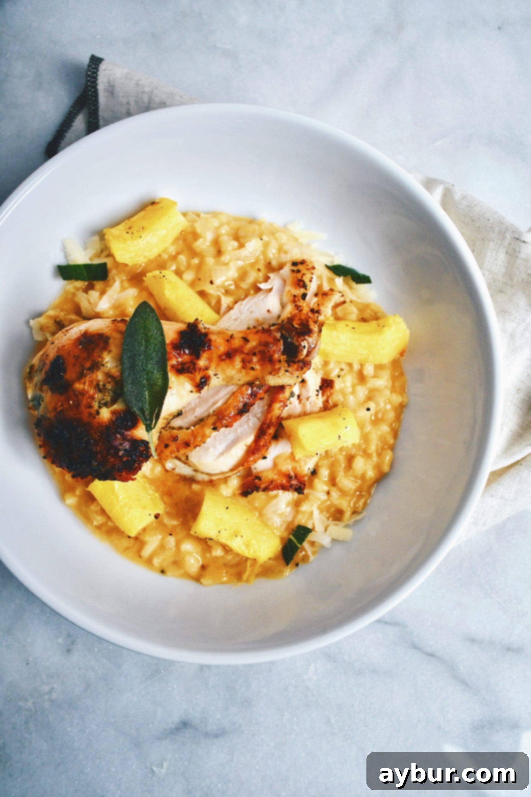 Creamy Pumpkin Sage Risotto 4 Pumpkin Sage Risotto served beautifully alongside Spatchcock Chicken, garnished with fresh herbs